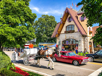 Horse-drawn carriage, bright red muscle car, and the Bavarian Inn in Frankenmuth Michigan.